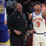 Mike Brown (L.) e Josh Hart assistem durante o jogo Knicks-Warriors em 15 de março de 2026.