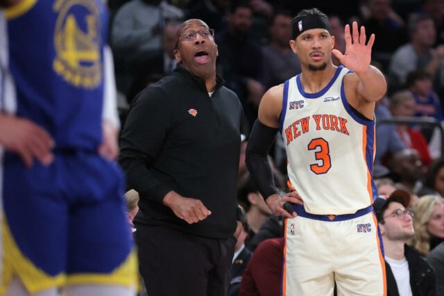 Mike Brown (L.) e Josh Hart assistem durante o jogo Knicks-Warriors em 15 de março de 2026. 