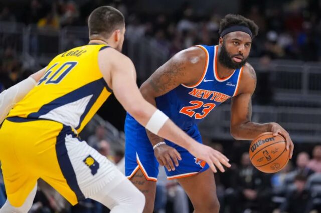 Mitchell Robinson, que pegou 22 rebotes, acertou Ivica Zubac durante a vitória dos Knicks por 101-92 sobre os Pacers em 13 de março de 2026, em Indianápolis.