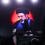 Um homem segura um cartaz com a imagem do novo líder supremo do Irã, Mojtaba Khamenei, com o falecido líder supremo iraniano, aiatolá Ali Khamenei, durante uma reunião para apoiar Mojtaba Khamenei, em meio ao conflito EUA-Israel com o Irã, em Teerã, Irã, 9 de março de 2026. (crédito: MAJID ASGARIPOUR/WANA (AGÊNCIA DE NOTÍCIAS DA ÁSIA OCIDENTAL) VIA REUTERS)