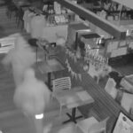 Imagens de segurança mostram duas figuras encapuzadas assaltando uma livraria.