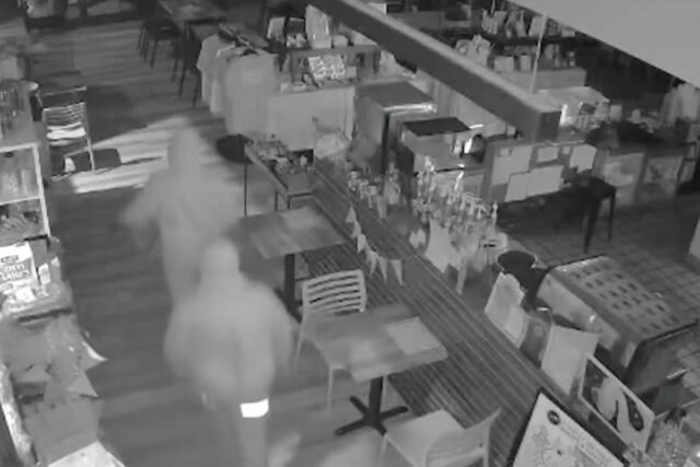 Imagens de segurança mostram duas figuras encapuzadas assaltando uma livraria.