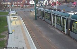 Momento em que motorista bêbado é flagrado dirigindo ao longo dos trilhos do bonde por um paramédico preocupado – que o arrasta para fora do carro Levi Gomez dirigiu ao longo da linha na parada de bonde University Boulevard de Nottingham