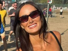 Mulher descobriu que tinha câncer cerebral terminal depois que mala caiu em sua cabeça Lauren Macpherson está em um campo de festival. As pessoas podem ser vistas em multidões atrás dela. Ela segura uma bebida rosa em um copo de plástico na mão esquerda e uma bolsa preta no ombro. Ela usa óculos escuros pretos, tem cabelos castanhos compridos e sorri para a câmera.