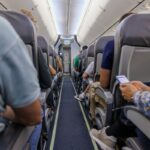 Stock image: a view of a plane aisle with passengers in their seats.