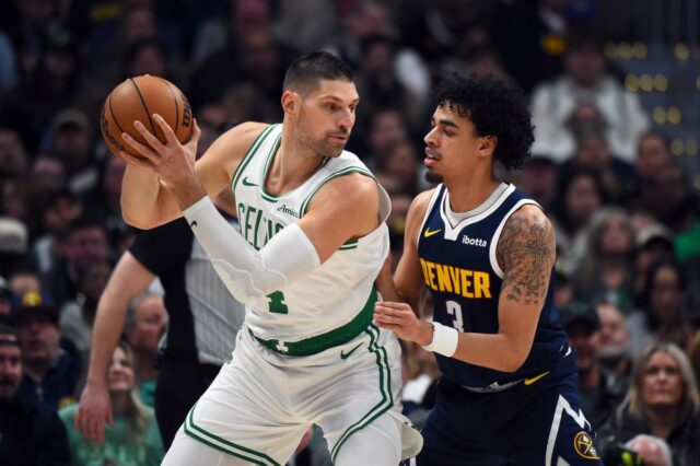 O pivô do Boston Celtics, Nikola Vucevic (4), trabalhou na trave contra o guarda do Denver Nuggets, Julian Strawther (3).
