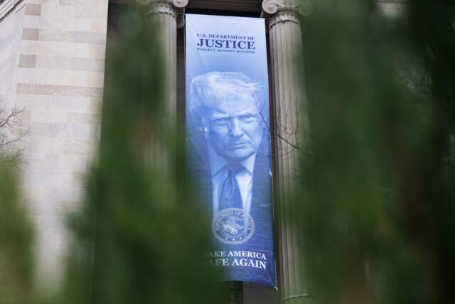 Uma faixa mostrando o presidente Donald Trump está pendurada no Departamento de Justiça, quinta-feira, 19 de fevereiro de 2026, em Washington. (Foto AP/Allison Robbert)