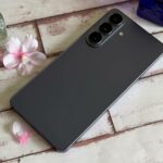 Vários smartphones modernos com uma etiqueta vermelha de aviso de 'Aumento de preço' e notas de dólar caindo em segundo plano.