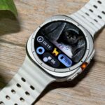 Samsung Galaxy Watch Ultra sentado em um tênis de ginástica mostrando o Samsung Health Tile