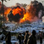 Uma bola de fogo irrompe após um ataque israelense perto de um acampamento que abriga pessoas deslocadas pela guerra no centro da Faixa de Gaza, em 25 de março.