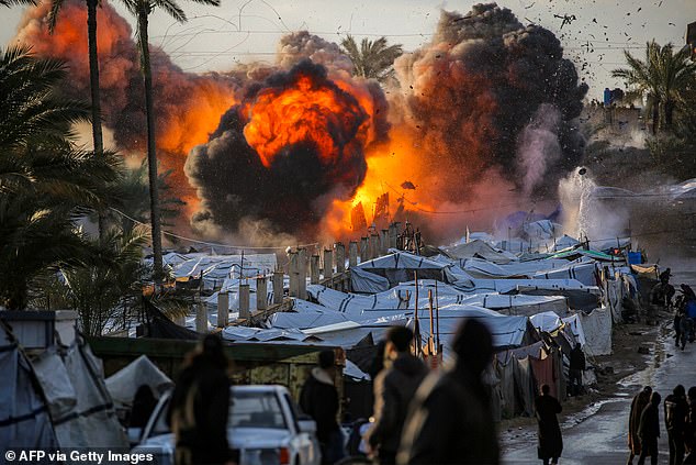 O Irã afirma que UM MILHÃO de combatentes estão preparados Uma bola de fogo irrompe após um ataque israelense perto de um acampamento que abriga pessoas deslocadas pela guerra no centro da Faixa de Gaza, em 25 de março.