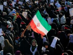 O Irã pode escolher seu próximo líder supremo nas próximas 24 horas: relatório Multidão de mulheres em hijabs e xadores, com uma bandeira iraniana no centro, num comício.