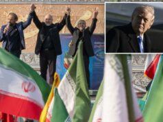 O Irã temeu que as negociações de Trump pudessem ser uma armadilha para assassinar um dos últimos líderes políticos sobreviventes do regime: relatório O presidente do Parlamento iraniano, Mohammad Bagher Ghalibaf, de mãos dadas com dois homens no palco de um comício pró-governo, com bandeiras iranianas em primeiro plano.