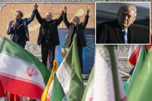 O presidente do Parlamento iraniano, Mohammad Bagher Ghalibaf, de mãos dadas com dois homens no palco de um comício pró-governo, com bandeiras iranianas em primeiro plano.