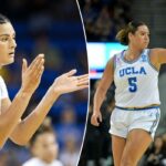 Lauren Betts batendo palmas durante um jogo de basquete.