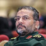 Gholamreza Soleimani, comandante das forças Basij do Irã, vestindo uniforme militar verde e óculos.