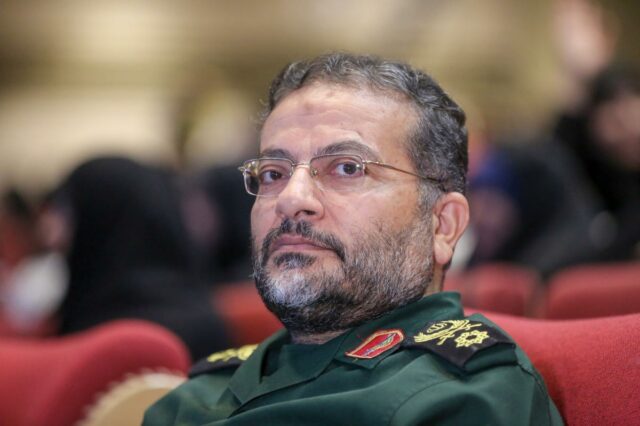 Gholamreza Soleimani, comandante das forças Basij do Irã, vestindo uniforme militar verde e óculos.