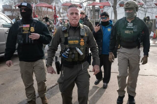 O chefe da patrulha de fronteira dos EUA, Gregory Bovino, segura um rifle enquanto patrulha um bairro de Chicago.