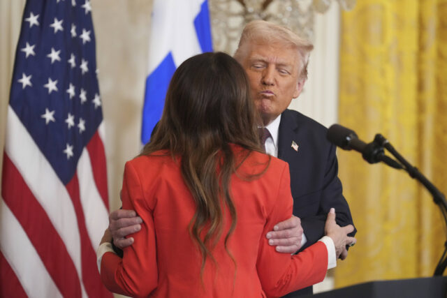 O presidente Donald Trump abraça a embaixadora dos EUA na Grécia, Kimberly Guilfoyle, em uma recepção em comemoração ao Dia da Independência da Grécia, na Sala Leste da Casa Branca, quinta-feira, 26 de março de 2026, em Washington. (Foto AP/Julia Demaree Nikhinson)