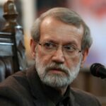 Ali Larijani, do Irã, acena enquanto apoiadores do Hezbollah jogam arroz para recebê-lo em Beirute durante uma visita ao Líbano em agosto de 2025.