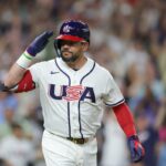 Kyle Schwarber, do time dos Estados Unidos, saúda o banco de reservas depois de fazer um home run de duas corridas.