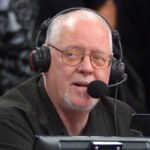 O locutor do Los Angeles Lakers, Lawrence Tanter, usando fones de ouvido e um microfone.