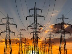 O melhor investimento em IA pode ser em tecnologia energética The sun sets behind transmission lines.