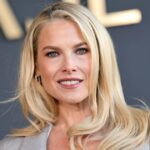 Therese Hellström @tesshell usa óculos de sol gatinho branco, vestido midi de lã listrado multicolorido com mangas compridas, bolsa Hermes de couro marrom, sapatos verdes de bico fino com pérolas metálicas, em 08 de abril de 2021 em Paris, França.