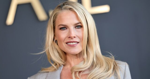 Therese Hellström @tesshell usa óculos de sol gatinho branco, vestido midi de lã listrado multicolorido com mangas compridas, bolsa Hermes de couro marrom, sapatos verdes de bico fino com pérolas metálicas, em 08 de abril de 2021 em Paris, França.