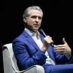 O governador da Califórnia, Gavin Newsom, falando ao microfone.