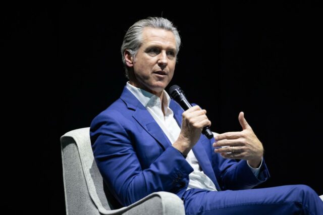 O que Newsom chama de “policiamento” de gênero nas escolas O governador da Califórnia, Gavin Newsom, falando ao microfone.