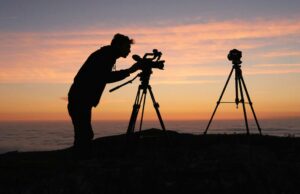 Obviamente, os videógrafos não deveriam comprar o MacBook Neo – nem os fotógrafos Obviamente, os cinegrafistas não deveriam comprar o MacBook Neo, mas os fotógrafos também não deveriam | Silhueta de um fotógrafo em uma encosta contra um pôr do sol