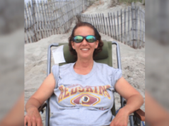 Operário da igreja de Luzerne condenado à prisão após roubar fundos para jogos de azar Operário da igreja de Luzerne condenado à prisão após roubar fundos para jogos de azar. Mulher usando óculos escuros relaxa em uma cadeira de praia em um caminho de duna arenosa, sorrindo enquanto veste uma camiseta cinza do Washington Redskins.