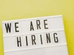 Os tokens de IA são o novo bônus de assinatura ou apenas um custo para fazer negócios? We Are Hiring sign, used in post about Weekday