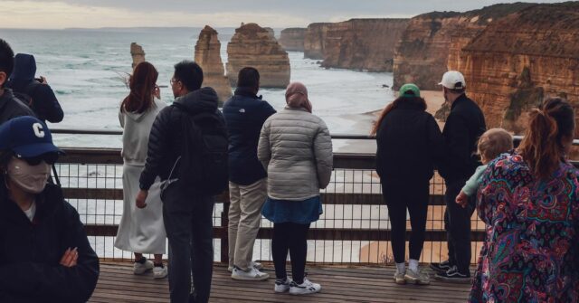 Visitantes na pitoresca costa de Victoria em Port Campbell. O popular ponto turístico está se desgastando lentamente ao longo dos anos, onde os visitantes vêm ver os 12 Apóstolos.