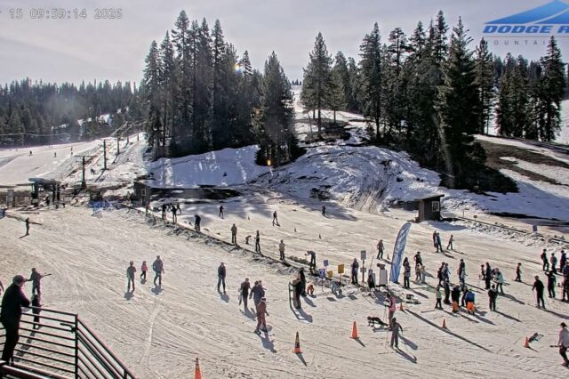 Outra estação de esqui fecha mais cedo porque a onda Uma movimentada estação de esqui com pessoas esquiando e praticando snowboard em um dia ensolarado.