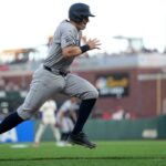O jogador da primeira base do New York Yankees, Ben Rice, corre em direção ao home plate.