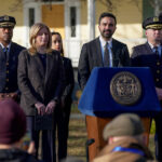 Jake Lang grita na calçada enquanto o prefeito de Nova York, Zohran Mamdani, fala durante entrevista coletiva na Mansão Gracie, segunda-feira, 9 de março de 2026, em Nova York. (Foto AP/Angelina Katsanis)