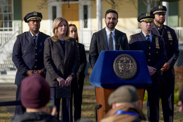 Jake Lang grita na calçada enquanto o prefeito de Nova York, Zohran Mamdani, fala durante entrevista coletiva na Mansão Gracie, segunda-feira, 9 de março de 2026, em Nova York. (Foto AP/Angelina Katsanis)