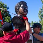Dois funcionários das instalações de artes e locais de Denver removem um busto de Cesar Chavez do Parque Cesar Chavez.