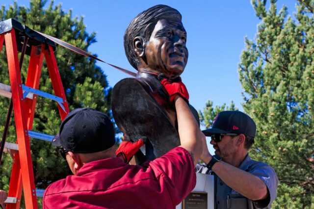 Dois funcionários das instalações de artes e locais de Denver removem um busto de Cesar Chavez do Parque Cesar Chavez.