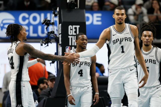 O armador do San Antonio Spurs, Devin Vassell, à esquerda, comemora com o atacante Victor Wembanyama (1) após marcar contra o Detroit Pistons durante o segundo tempo de um jogo de basquete da NBA na segunda-feira, 23 de fevereiro de 2026, em Detroit.