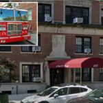 Um caminhão vermelho número cinco do Corpo de Bombeiros de Nova York estacionado na rua de Greenwich Village.