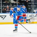 Brennan Othmann, do New York Rangers, patinando no gelo durante o aquecimento.
