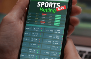 Regulador australiano penaliza seis empresas de apostas por falhas do BetStop protegendo autoexcluídos ACMA diz que as falhas das empresas de apostas minaram o sistema nacional de autoexclusão da BetStop. Mão segurando um smartphone exibindo uma interface de aplicativo de apostas esportivas com probabilidades ao vivo, listas de jogos e dados flutuantes de apostas.