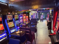 Repetição de ataque ao jogo no condado de Bexar leva a prisões e casos de crueldade Interior de uma sala de jogos ilegais em San Antonio com fileiras de caça-níqueis, cadeiras e luzes de neon durante invasão no condado de Bexar