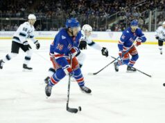 Sam Carrick parece estar indo para o Sabres enquanto os Rangers continuam a se reequipar Jogadores do New York Rangers com camisas azuis enfrentando jogadores do Utah Mammoth com camisas brancas durante um jogo de hóquei.