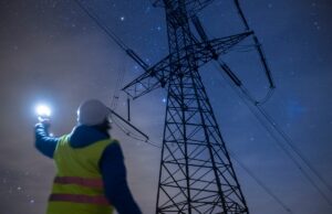 Samsung aposta que esta startup insular pode domar a rede com software e baterias High-voltage engineer working on power lines at night.