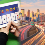 Senadores de Minnesota promovem projeto de lei para proibir jogos de sorteios online no estilo cassino. Exibição do tablet “VOCÊ GANHOU!” com uma mão de pôquer royal flush ao lado do horizonte de Minneapolis e do tráfego rodoviário, simbolizando o debate sobre jogos de azar online em Minnesota.