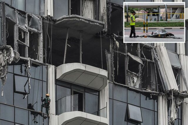 Um campanário avaliando os danos a um edifício após um ataque de drone em Dubai.